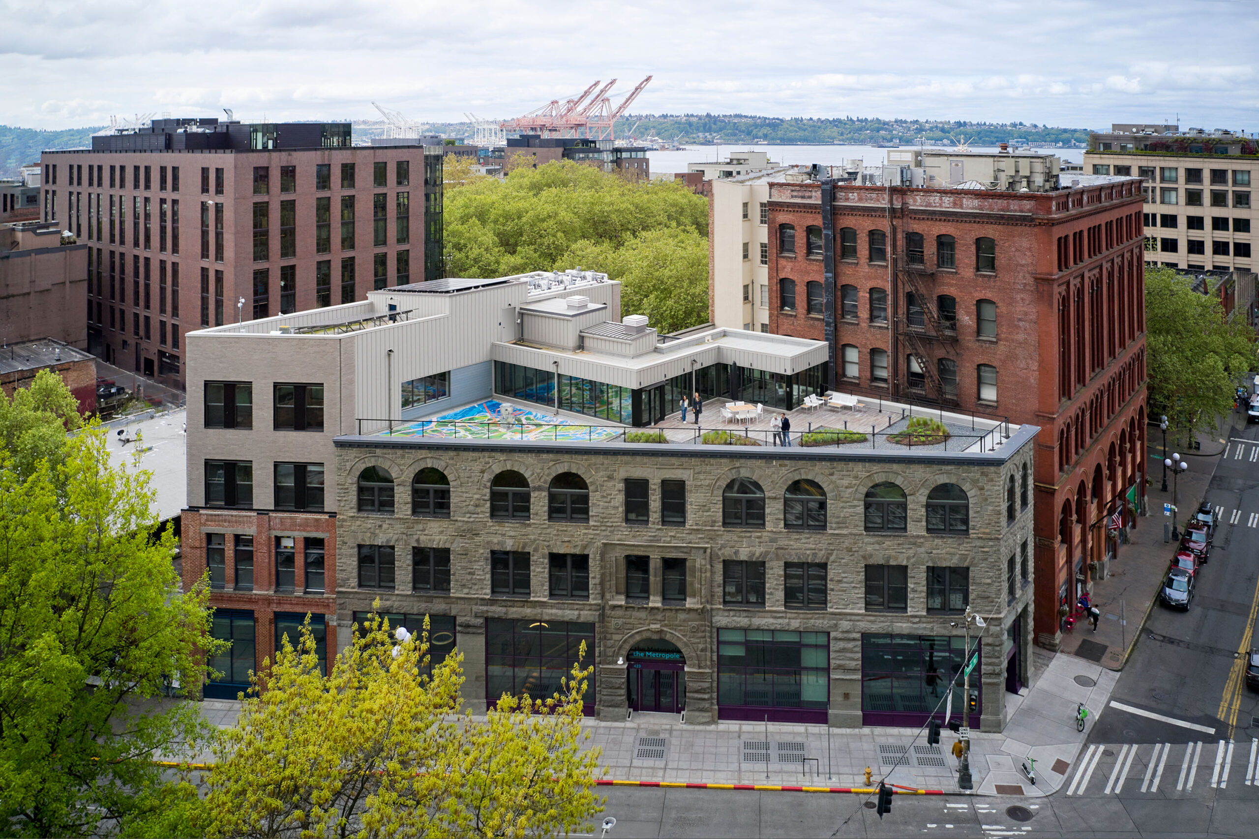 Aerial view of The Metropole building in Seattle, featuring a modern rooftop play area and surrounding historic brick façades